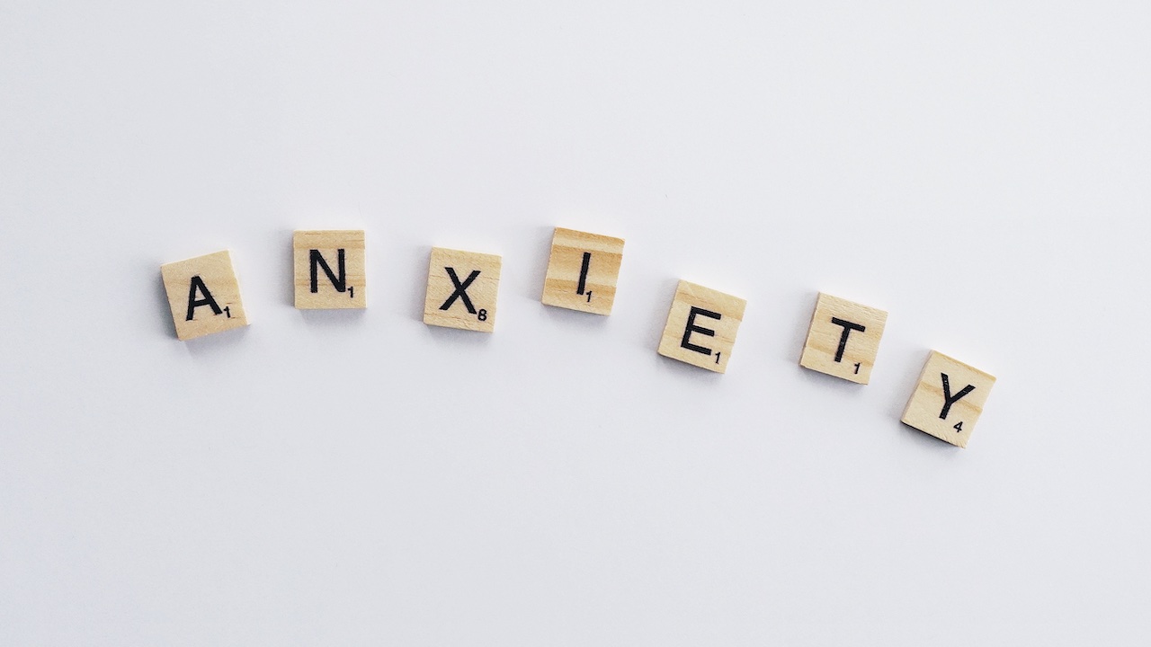 Holzfliesen buchstabieren das Wort "anxiety".